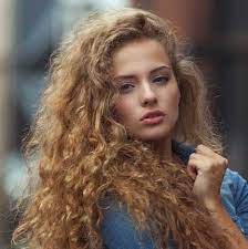 Ritratto di ragazza afroamericana ispirata alla calma toccare il palmo del petto credere che i sentimenti abbiano un bell'aspetto grato indossare vestiti eleganti di lucentezza verde isolati su sfondo di colore giallo. Capelli Ricci 2015 Le Tendenze Dell Estate