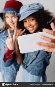 Happy Interracial Girls Showing Victory Rock Signs While Taking Selfie  Stock Photo by ©Ischukigor 453055530