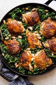 One Pot Braised Chicken With Kale And White Beans The Modern Proper Recipe Oven Chicken Recipes Braised Chicken Thighs Dutch Oven Chicken Thighs