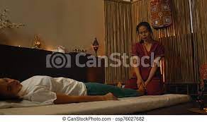 Asian performs massage in national clothes of thailand. asian spa salon in  europe. young caucasian woman relaxes while | CanStock