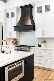 A Beautiful Black Range Hood Picks Up The Tone Of The Nearby Island Housetrends Kitchen Hood Design Kitchen Range Hood Modern Farmhouse Kitchens