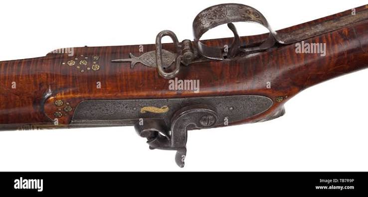 A Persian, gold-inlaid percussion rifle, 19th century, Round, rifled Damascus barrel in 17 mm calibre with cannon muzzle. The surface of the barrel inlaid with knotted ribbon ornaments and arabesques in gold.
