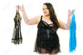 Mujer Adulta Madura Con Lencería De Satén Recogiendo Ropa De Dormir. Mujer  De Talla Grande Que Se Siente Cómoda Con Ropa Interior Sensual. Fotos,  retratos, imágenes y fotografía de archivo libres de