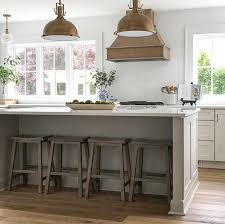 Coastal Farmhouse Kitchen With No Upper Cabinets And Windows Flanking Range Hood Grey Kitchen In 2020 Kitchen Design White Kitchen Peninsula Off White Kitchen Cabinets