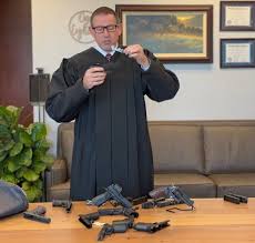 Joe Dudek: "Judge VanDyke recorded his video explanation of his dissent  sitting in front of a semi-automatic mounted