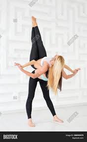 It's pretty tough, but most people with normal mobility will find it accessible after practicing it a bit. Two Young Women Image Photo Free Trial Bigstock