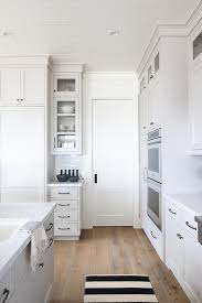 Appliances such as refrigerators, dishwashers, and ovens are often integrated into kitchen cabinetry. Light Gray Kitchen With White Pantry Pocket Door Transitional Kitchen
