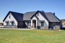 The large family room has vaulted ceilings, a beautiful brick. Homes For Sale In Granbury Tx With Transitional Exterior And Archways Front Yard Landscape Ranch Style Home Rustic Wood Stone And Brick Exterior Texas Home Texas Ranch Home Traditional Home White Stone