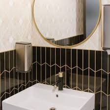 Black And Gold Tiles Bathroom Commercial Bathroom With Vertically Stacked Black Chevron Tile With Gold Grout And Metallic Gold Gold Bathroom Black And Gold Bathroom Metallic Tiles Bathroom