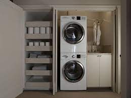 Gray laundry room boasts side by side stacked front load washer and dryers enclosed with a gray cabinet and upper storage fitted for larger households. 75 Beautiful Stacked Washer Dryer Laundry Room Pictures Ideas Houzz