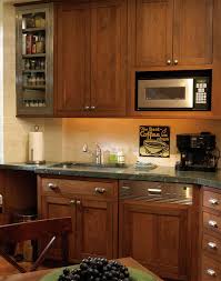 Traditional kitchen style with a variety of black kitchen cabinets, stainless steel appliances, large white rectangle sink and beige/dark brown granite surfaces. Stylishly Sleek Kitchen Cabinets Plain Fancy Cabinetry