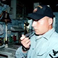 Boatswain's Mate 3rd Class Jake Lewis inspects a ceremonial quarterdeck  helm aboard Nimitz-class aircraft carrier USS Carl Vinson (CVN 70).