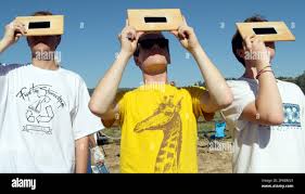 Nick Bremner, Aaron Bremner, and Joel Bremner, from Sonoma, Calif., take a  look at the solar eclipse through homemade masks out of welding glass in  Upper Bidwell Park at the Kiwanis Chico