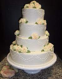 4 Layers Of Our Buttercream Iced Cake With Dotted Swags And Pale Yellow Roses With A Hint Of Sprayed Pink Traditional Wedding Cakes Cake Ice Cake