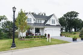 Modern white farmhouse exterior like the pop out window and metal roof accent. Timber Trails Farmhouse Tour Jettset Farmhouse