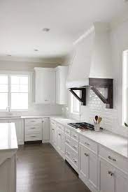 Gorgeous White Kitchen Is Fitted With A White Shiplap Hood Accented With Espresso Stained Corbels Gorgeous White Kitchen Kitchen Hoods Trendy Farmhouse Kitchen