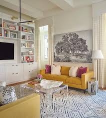 A refined formal dining space with a navy accent wall, lemon yellow chairs, a colorful table and a bold artwork on the wall. Mustard Yellow Couch With Lucite Coffee Table Transitional Living Room