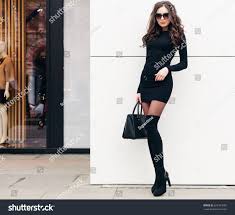 A Super Fashionable Long Legged Brunette Girl With Long Hair Dressed In A Short Black Dress Black High Heels With A La Black Short Dress Fashion Brunette Girl