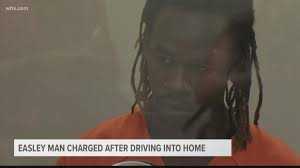 Easley man charged after driving into home