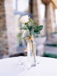 White flower arrangements and gold vases. Simple Yet Elegant Centerpiece Green Leaves And A White Rose With Gold Ribbon Tri Green Wedding Centerpieces Rose Centerpieces Wedding Wedding Centerpieces