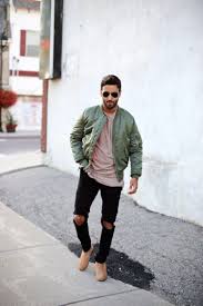 With striped shirt, cuffed jeans and pastel color coat. Green Bomber Jacket Taupe T Shirt Black Distressed Jeans Suede Chelsea Boots Bomber Jacket Outfit Boots Outfit Men Mens Outfits