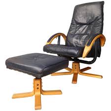 A lever, conveniently located under the right arm, brings the chair to a full reclining position. Danish Design Wooden And Leather Recliner And Swivel Armchair With Ottoman For Sale At 1stdibs
