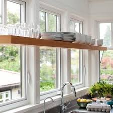 The dark window panes are a nice contrast to the wood on the window shelf and plants. Shelf In Front Of Window Design Ideas