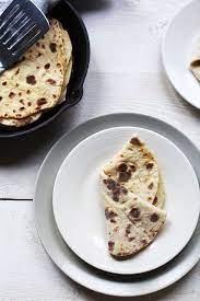 How To Make Potato Flatbread Roti With Roti In A Pan And On A Plate Food Roti Recipe How To Make Potatoes