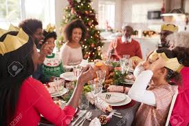 We had one cracker without a hat and motto, 1 without anything at. Mixed Race Multi Generation Family Sitting At The Christmas Dinner Table Reading Jokes And Wearing Paper Party Hats From Christmas Crackers Close Up Stock Photo Picture And Royalty Free Image Image 115490461