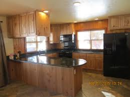 Natural Stain Knotty Alder Kitchen Cabinets Complete With Large Tile Flooring Black Countertops And App Alder Cabinets Kitchen Cabinets Alder Kitchen Cabinets