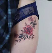 The design features a pretty pink rose with green leaves around the outside. Hip Tattoo Ideas Popsugar Beauty
