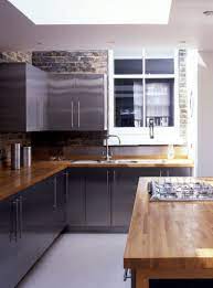 A durable solid surface worktop, with seamless joins and a silky smooth finish. Stainless Steel Cupboards Give This Kitchen A Glossy And Reflective Finish Paired With Timber Worktops Steel Cupboard Wood Worktop Kitchen Kitchen Design