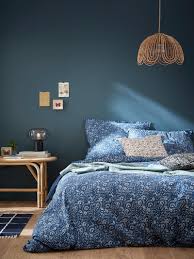 White nightstand displaying a marble and brass lamp in a styled bedroom designed beside a bed dressed with white bedding for a bright and cheerful look. Round Glass And Marble Lamp Green Home