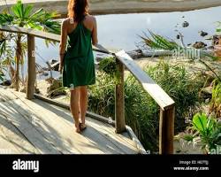Image of young Cambodian woman admiring the sunset over a deserted beach at Kaktus resort on Koh Ta Kiev in Sihanoukville