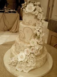 A four tier marble cake decorated with cascading roses in shades of purple and aqua blue. Wedding Cakes Fancy Cakes Bakery
