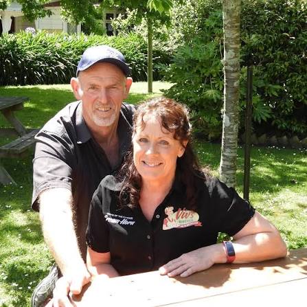 Two members of the Viv's Kitchen team in branded shirts, smiling at an outdoor table