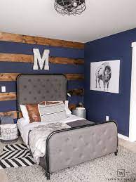 Lots of boys bedroom ideas to inspire you for your own space! Rustic Boy S Room With Dark Navy Walls And Wood Accents Love The Industrial Decor And Pops Of Pattern Rustic Boys Bedrooms Boys Room Blue Blue Boys Bedroom