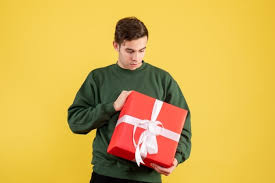 Best gift for men who love. Front View Young Man With Xmas Gift Pointing At Xmas Gifts Standing On Yellow Background Free Picture On Freepik
