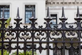 A custom wrought iron railing can beautifully accent a straight or curved staircase. Old Ornamental Wrought Iron Fence With Spiked Tops In Front Of Stone Building Stock Photo Picture And Royalty Free Image Image 36251425