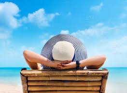 An attractive looking mature woman is sitting relaxed and peaceful at the beach, meditating and in spiritual mood. Woman In Hat Relaxing On Beach Looking At Sea Stock Photo 6aff2a4a 215c 438a 994e Df10bf0ddc9b