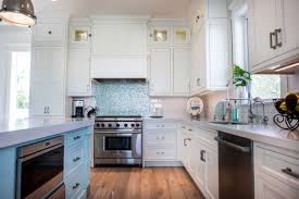 Coastal farmhouse kitchens make use of plenty of bright whites and reclaimed woods, apron style sinks and lantern pendant lights. Coastal Style White Kitchen With Blue Island Crystal Cabinets