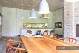 All have been placed so that they face out towards the large floor to ceiling windows, which allow a mass of light to emanate into the space. Modern Open Plan Kitchen And Dining Room Simplicity Wealth Stock Photo 347663048