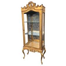 The cabinet's antique bronze handles for the cabinet doors help expand the entire height of the cabinet. Antique French Provincial Carved Gold Glass Curio Cabinet Scranton Antiques