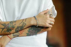 Tatuador mostrando uma tatuagem realista de flor