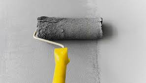 Detalle de un profesional aplicando Pintura Gris Alto Tráfico con rodillo sobre piso industrial