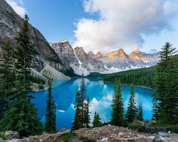 Image of freshwater lake with clear blue water, surrounded by trees and mountains
