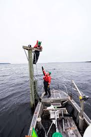 Petty Officer 3rd Class Benjamin Lassen hands Petty