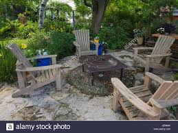 Hier punkten gartentische mit steinplatte. Holz Adirondack Stuhle Um Einen Tisch Auf Der Steinplatte Terrasse In Einem Angelegten Garten Im Hinterhof Im Sommer Stockfotografie Alamy