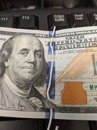 You can slide through a paper clip between the ribbon and paper