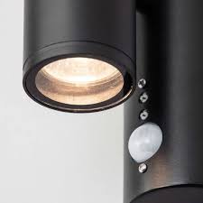 Black and woodgrain finish motion sensor dusk to dawn outdoor wall sconce with striped clear glass. Irela Black Up Down Outdoor Sensor Wall Light Litecraft